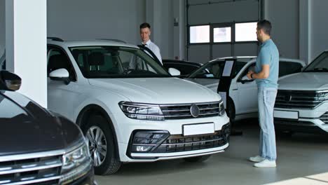 customer and salesman viewing cars in showroom