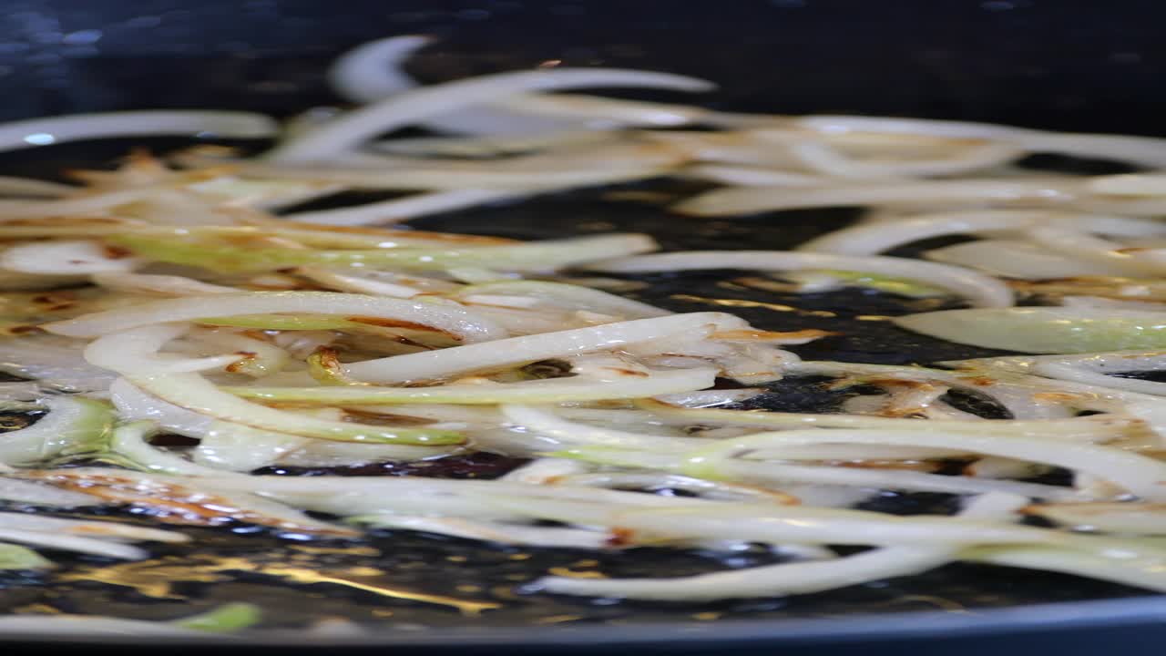 Frying sliced onions in a pan