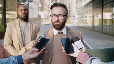 man giving interview to tv journalists outdoors on street