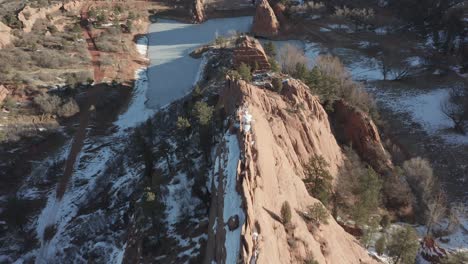 aerial dolly over red ridge with snow and frozen lake