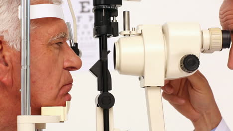 doctor examining eyes of elderly patient