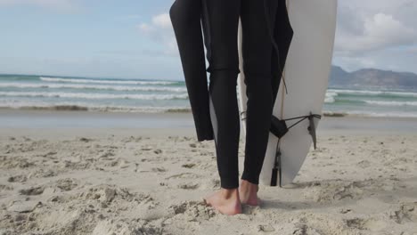 Young-man-on-beach-with-surfboard