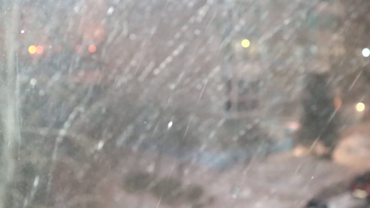 4k 영상, 저녁 겨울 도시의 초점을 맞추지 않은 불빛과 랜턴의 배경에 눈이 내리는