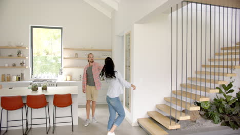 a diverse couple stands in a bright, modern kitchen at home