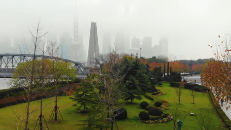 drone revealing the monument to the people's heroes and the very foggy shanghai's skyline