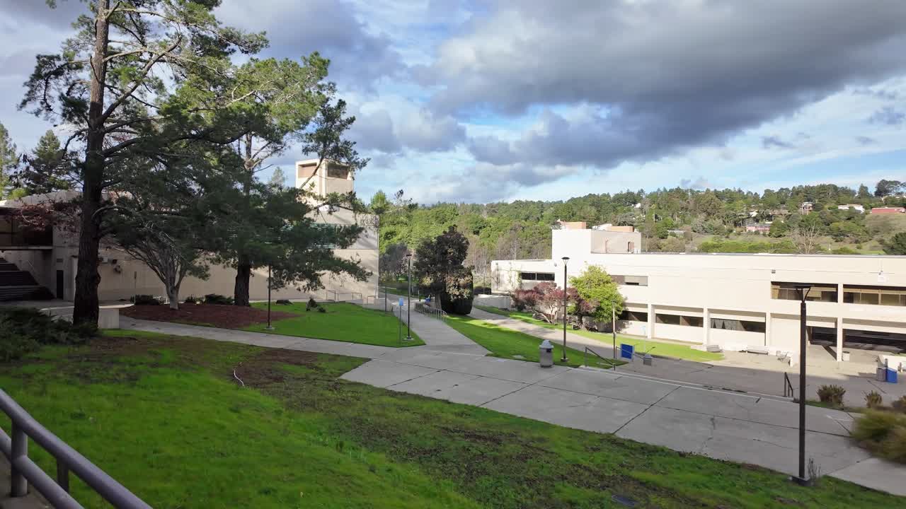 Las vistas de la tarde mientras se camina recorren los senderos del Merritt College mientras la luz cálida toca los edificios de hormigón, los árboles y las laderas
