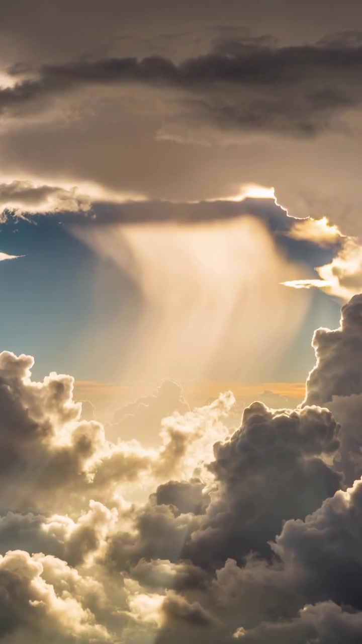 Video verticale: Sole basso che squarcia la volta, un raggio luminoso e nuvole che si spostano, mostrando un controluce.