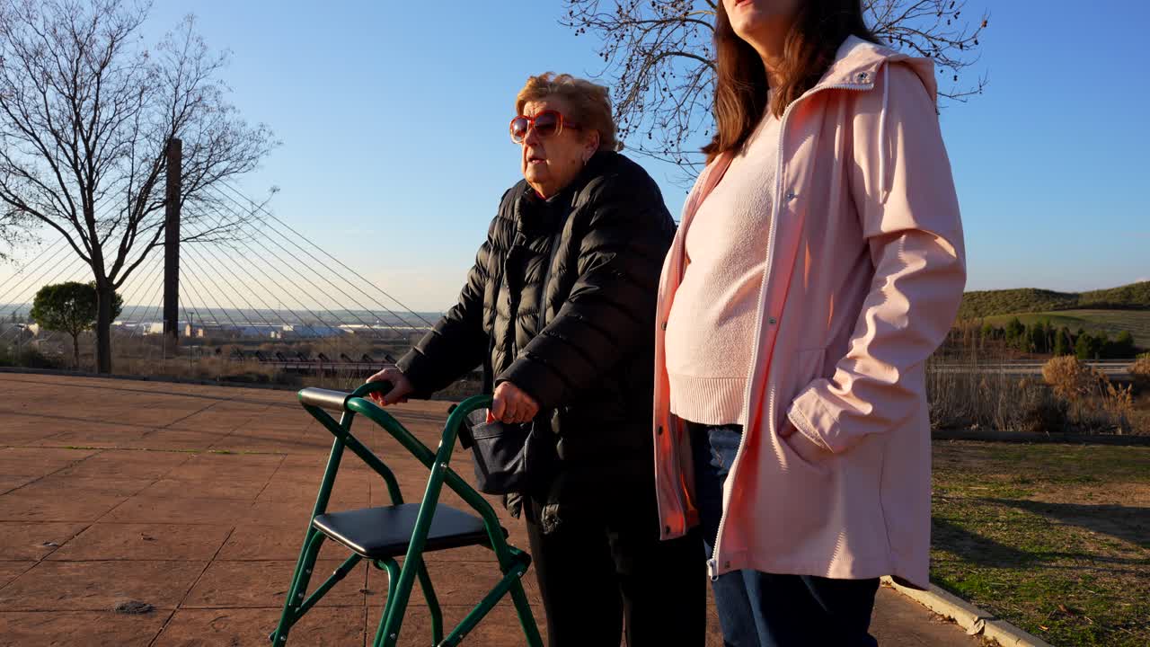 Mobility aid user and pregnant relative engaged in social interaction