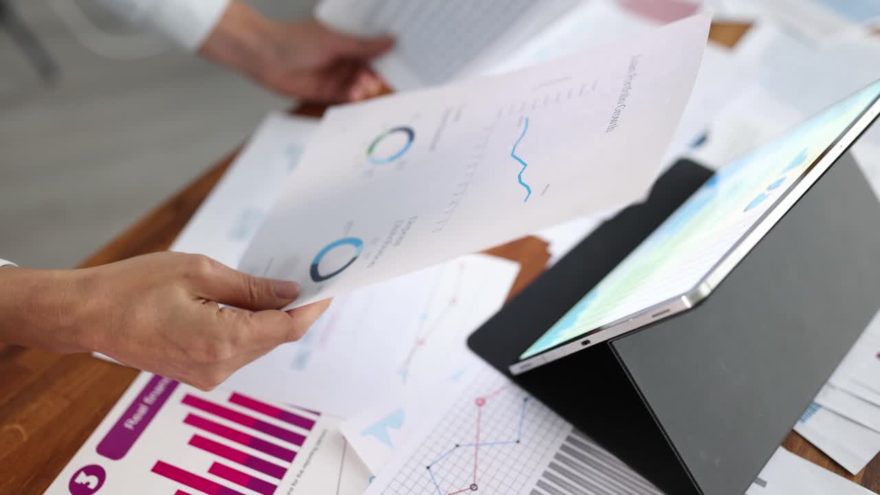 Hands Analyzing Business Reports and Financial Data with a Tablet
