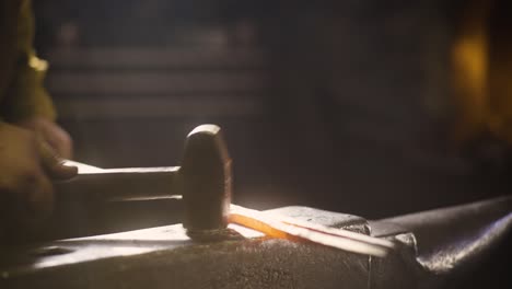 blacksmith striking metal with hammer