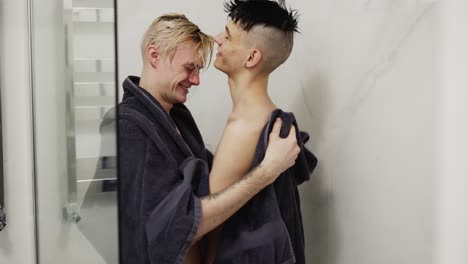 cute couple of men with towel drying each other after shower