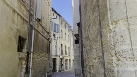 small alley in a french town with many shutters and doors in the shining sun