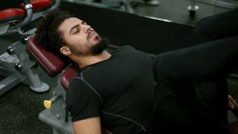 Young-man-using-leg-press-machine-in-gym