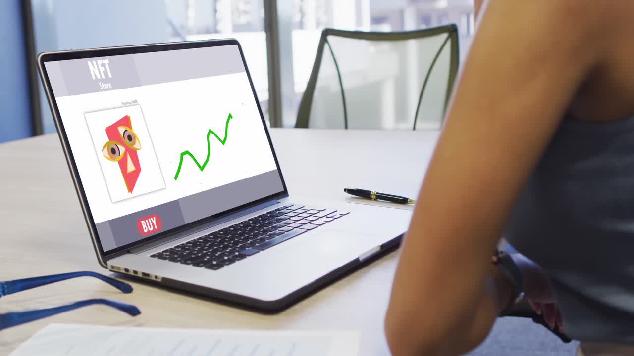 video de una mujer biracial trabajando en una computadora portátil con nft en la pantalla