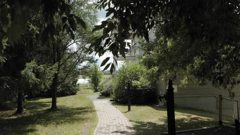 Caminar-Por-Un-Sendero-Del-Jardín-En-Un-Acre-Para-Revelar-Una-Hermosa-Casa-De-Huéspedes-De-La-Mansión-Detrás-De-Los-árboles-En-El-Centro-De-Bodas-Y-Spa-Strathmere