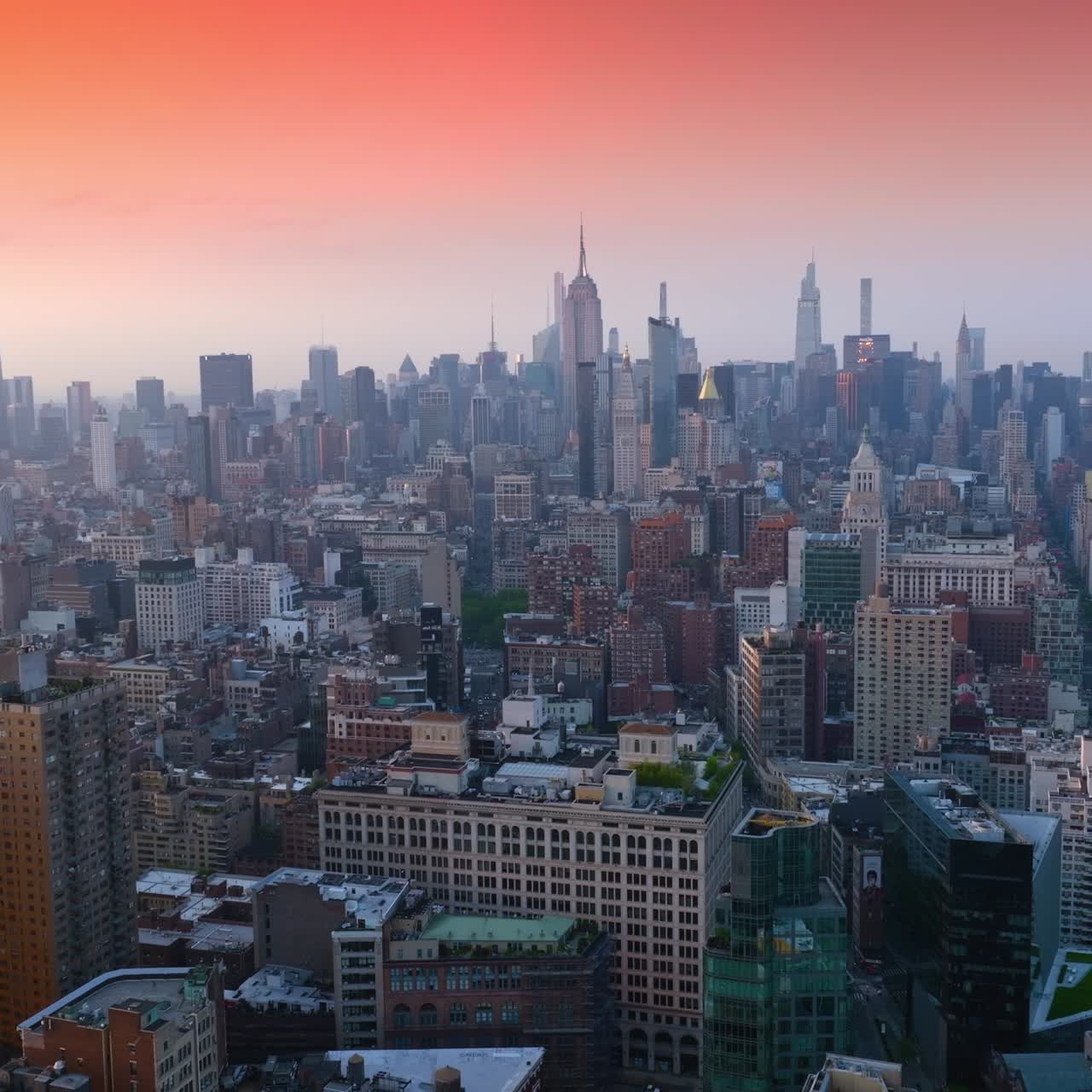 Panorama rilassante e appagante di New York ai raggi del sole al tramonto. Incantevoli cieli rosa e arancioni sulla magnifica città. Vista dall'alto