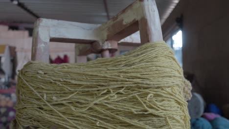 close-up shot of yarn wrapped around the equipment with yarn hanging