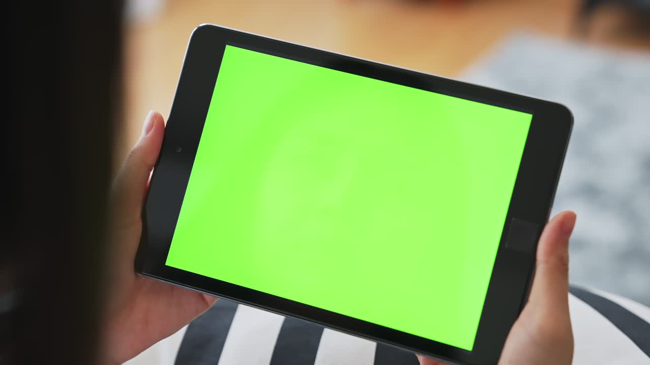 인터넷을 위해 녹색 화면을 가진 디지털 태블릿을 손에 들고 있는 여성의 클로즈업, 광고를 위해 크로마 키 스크린.