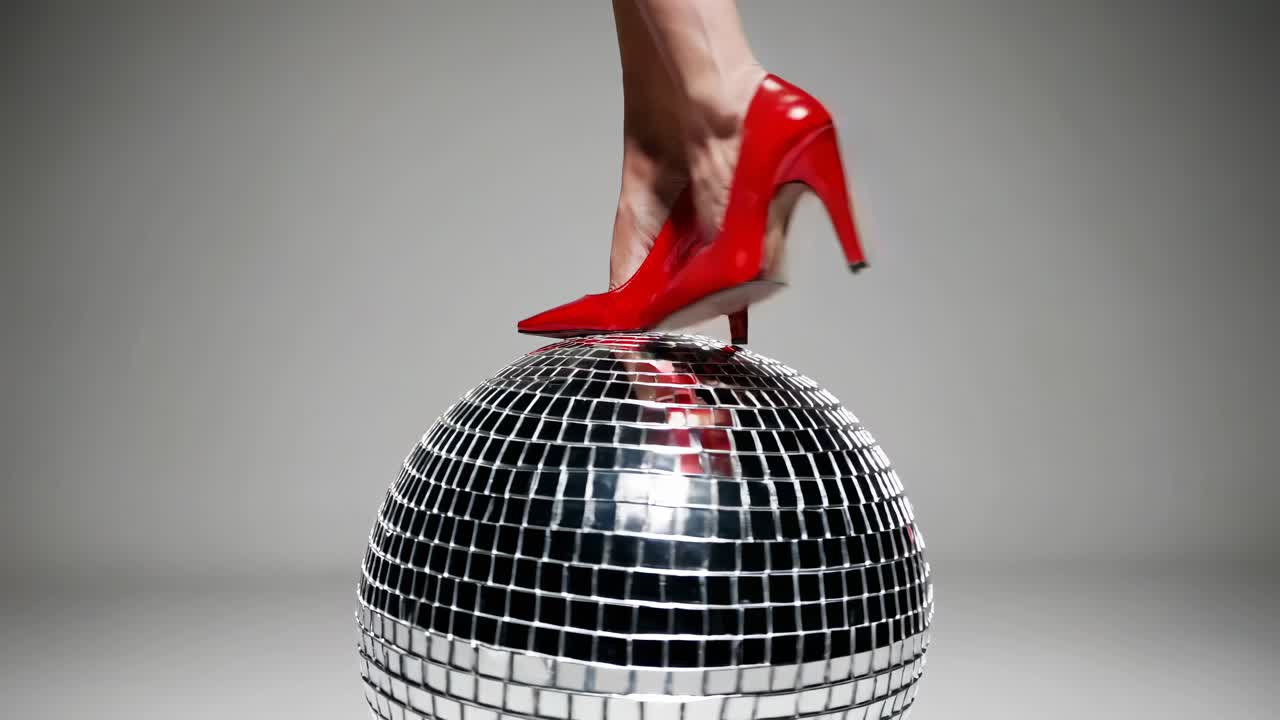 Rote High Heels auf einer Discokugel