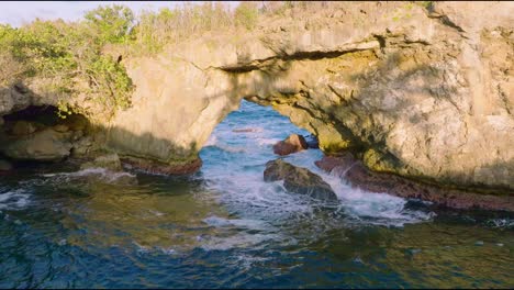 breaking sea waves at the natural arch of la hondonada in las galeras, samana, dominican republic