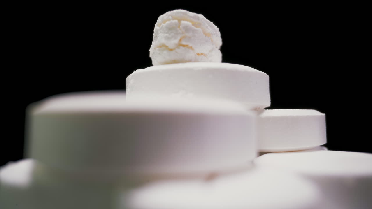 용해 가능한 비타민 태블릿의 스택이 검은 바탕으로 변합니다.