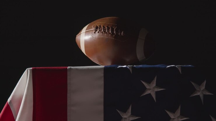 low-key-beleuchtung, studioaufnahme des american football auf der stars and stripes-flagge 7