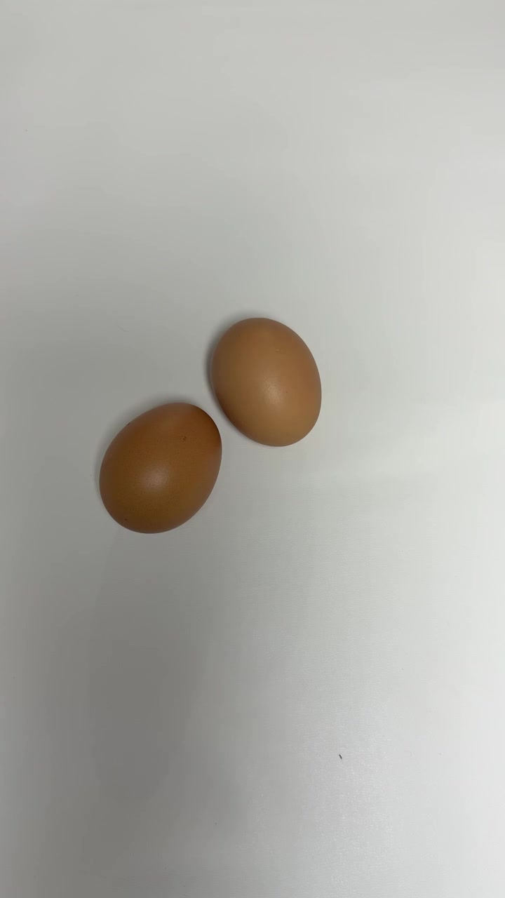 Hand Moving Brown Eggs on White Surface
