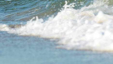 fotografía de cerca de las vigorosas olas del océano chocando con la espuma blanca