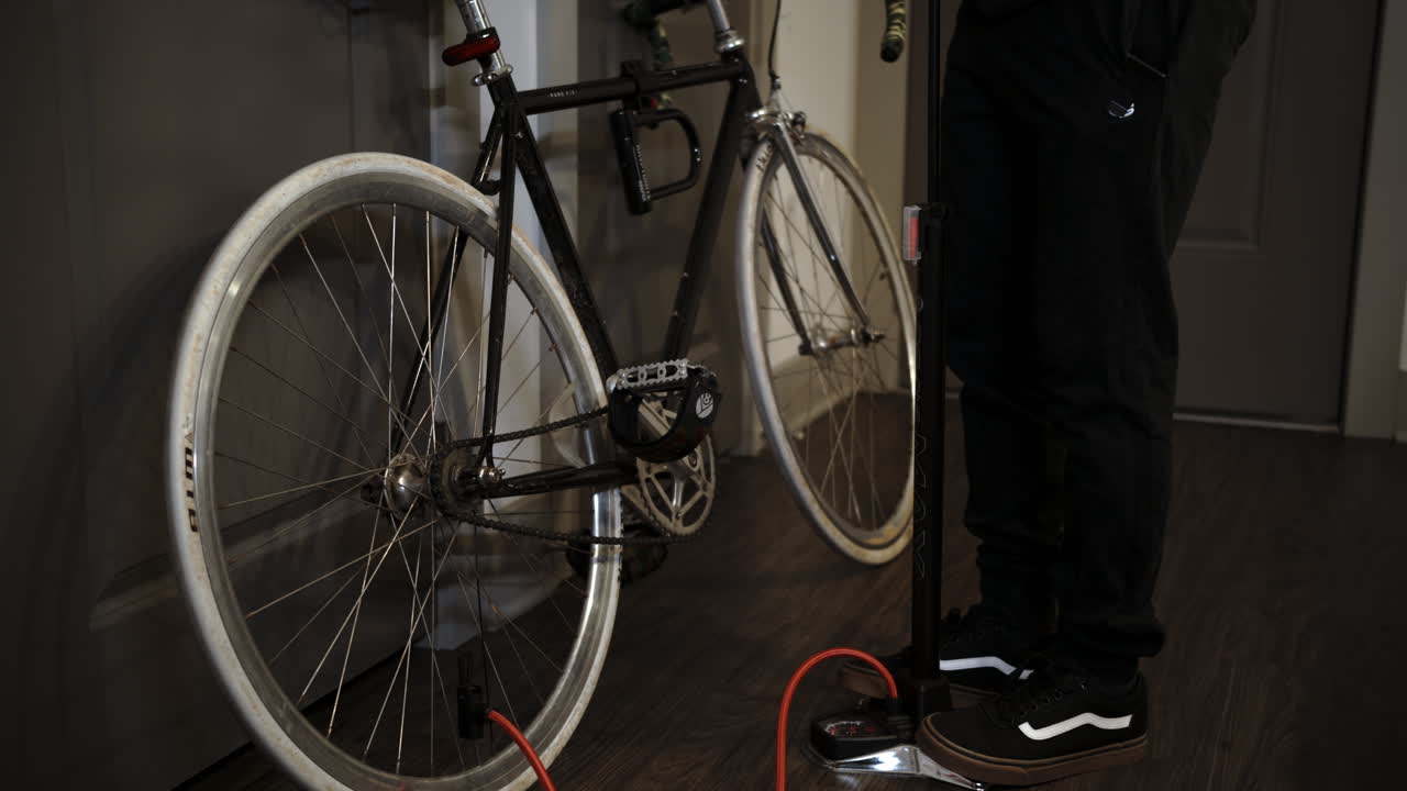 서있는 펌프로 자전거에 공기를 펌핑하는 남자