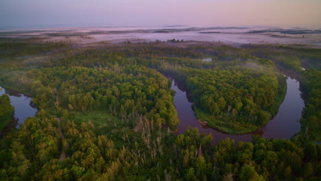 drone disparado volando sobre el sinuoso río manistee al amanecer