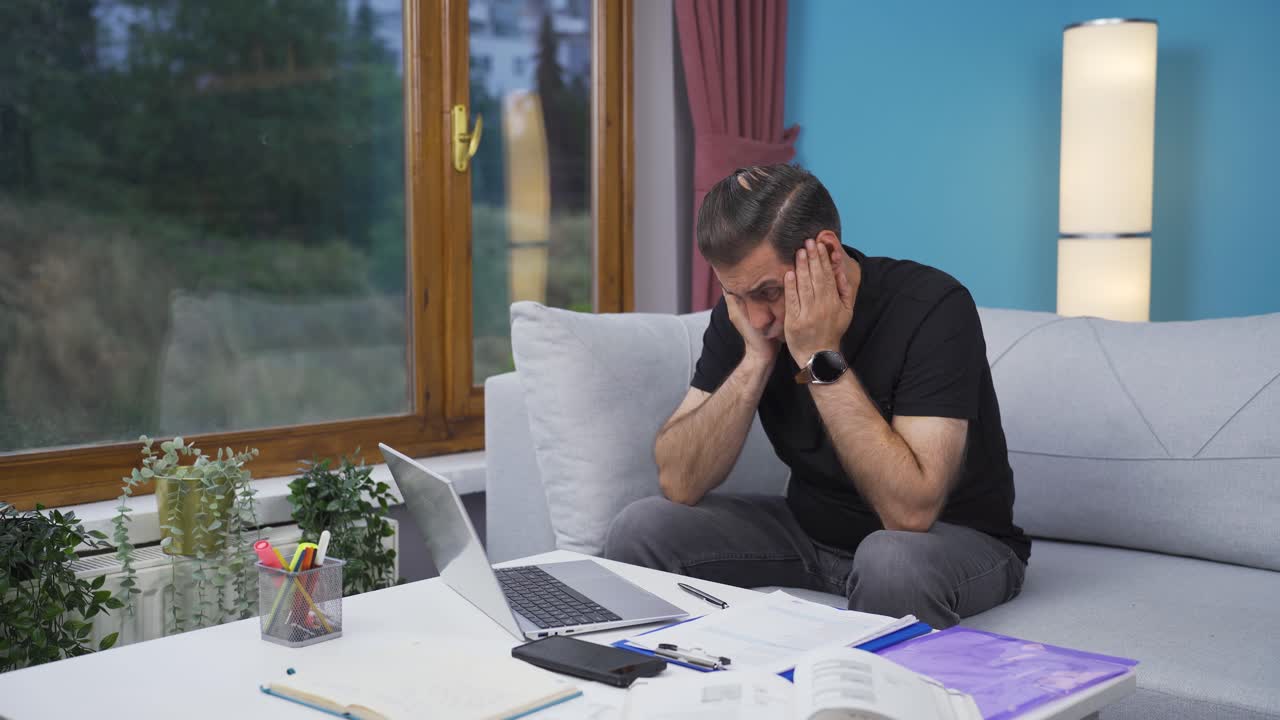 uomo che lavora in ufficio a casa che pensa in modo preoccupato.