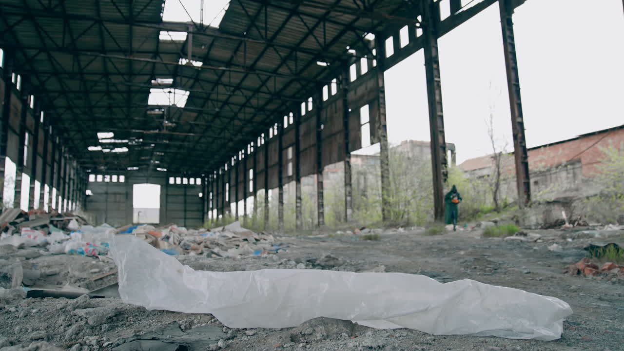 Abandoned building with garbage inside. Scientist in protective uniform in destroyed building. Biological attack.