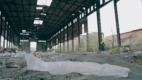 abandoned building with garbage inside. scientist in protective uniform in destroyed building. biological attack.