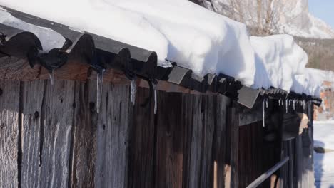 Dach-Einer-Berghütte-Aus-Holz,-Bedeckt-Mit-Schnee-Und-Gefrorenen-Tropfen