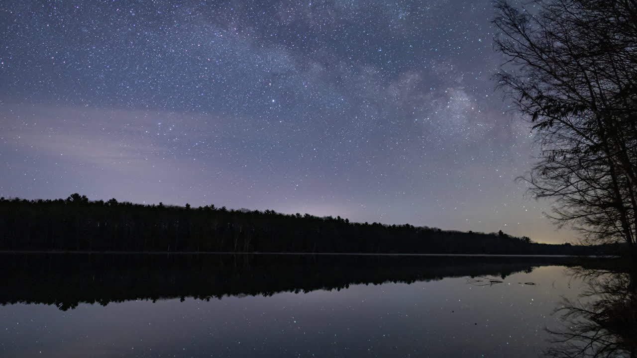 미시간 북부의 작은 호수 위로 떠오르는 은하수의 시간 경과