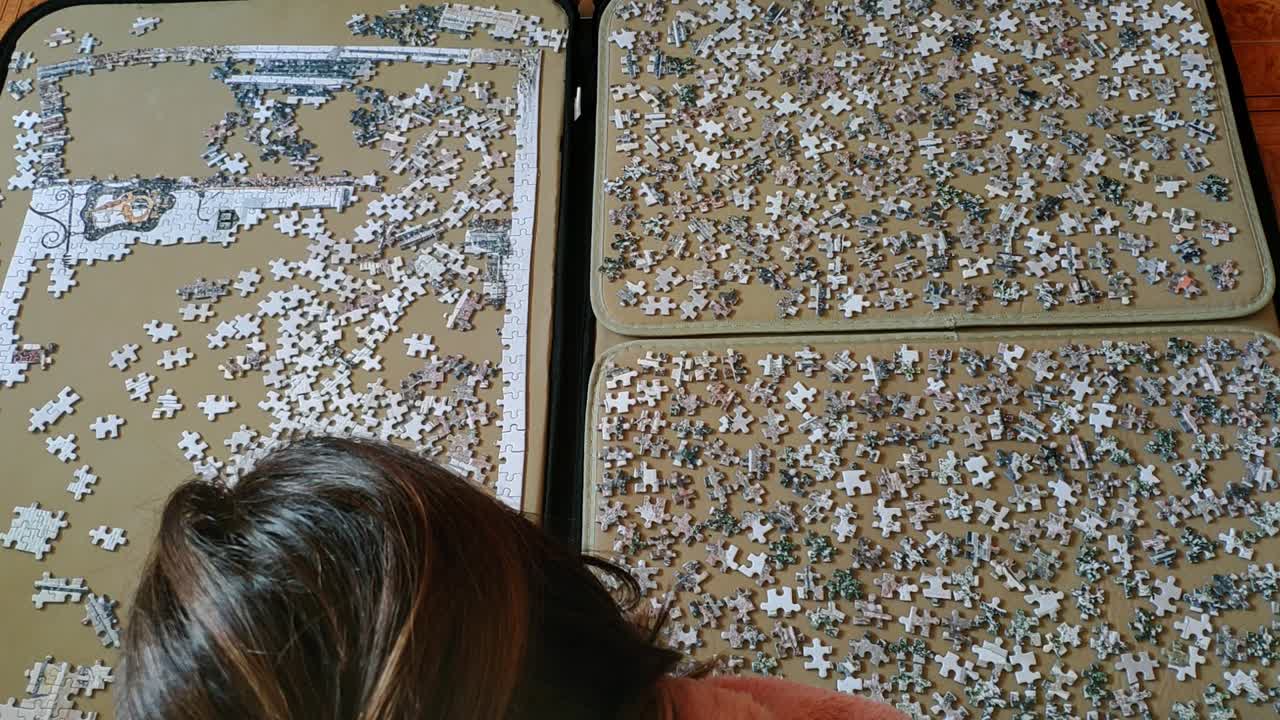 vista superior de una mujer con ropa cómoda en hme trabajando en un gran rompecabezas
