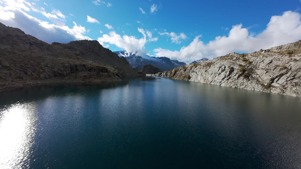 Drone flying at low altitude over Pirola Lake, Alpine landscape, Valmalenco, Alps in Italy. Aerial FPV
