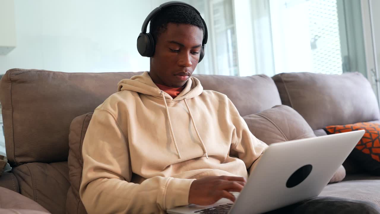 Man using laptop on couch at home
