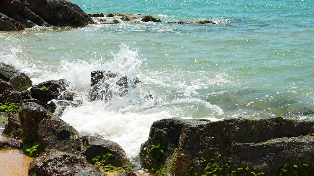 바다의 파도가 해변 한가운데의 바위에 부 ⁇ 히고