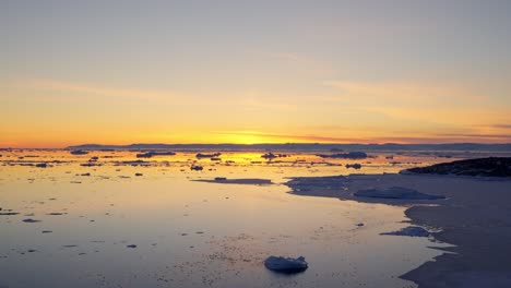 luz dorada del sol sobre el mar y el hielo del fiordo de hielo de ilulissat