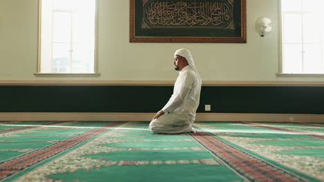 a muslim man praying in a mosque