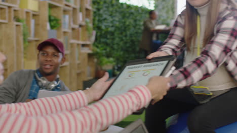 Gente-De-Negocios-Creativa-Reuniéndose-Con-Una-Mujer-Embarazada-Líder-Del-Equipo-Usando-Una-Tableta-Digital-Viendo-Información-De-Investigación-De-Mercados-En-La-Pantalla-Intercambiando-Ideas-Diversos-Colegas-Que-Trabajan-En-La-Oficina