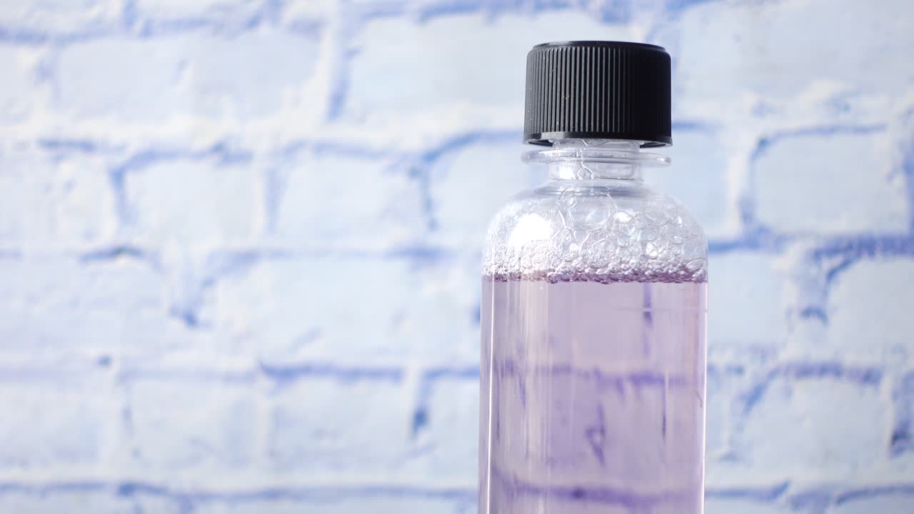 líquido para enjuague bucal en un recipiente sobre la mesa,