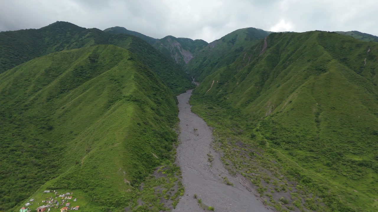Lembah bervegetasi hijau subur El Infiernillo dan sungai drainase di Chicoana, Provinsi Salta, latar belakang udara bergerak ke kanan