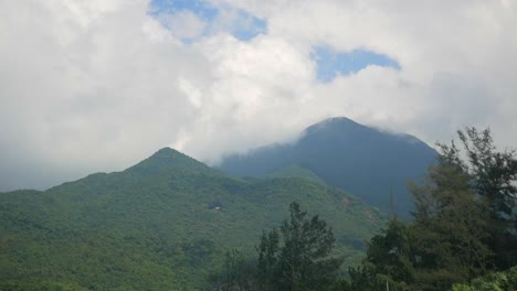 green mountains in the distance with white clouds