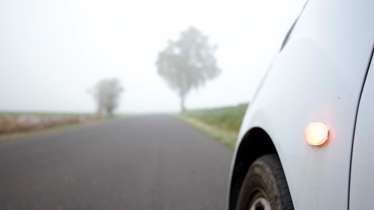 Car parked while orange hazard light is blinking on the road -  close up