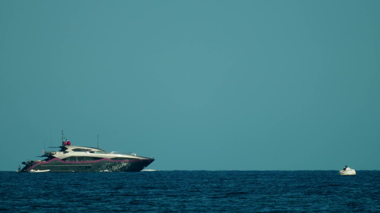 Superyacht di lusso moderno che solca il mare aperto di un blu profondo sotto un cielo turchese limpido e senza nuvole. Ideale per concetti legati all'estate e ai viaggi.