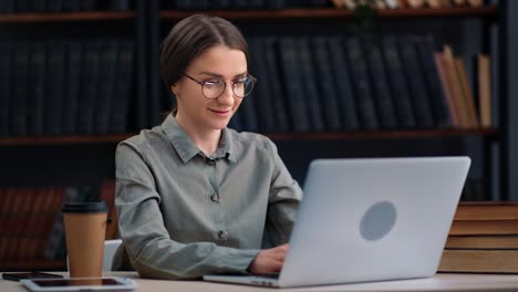 smiling business woman working chatting laptop e learning distance education at library desk