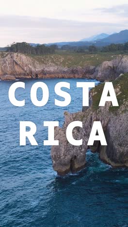 Vertical-Video-Drone-Shot-Of-Island-Coastline-With-Ocean-Overlaid-With-Animated-Graphic-Spelling-Out-Costa-Rica