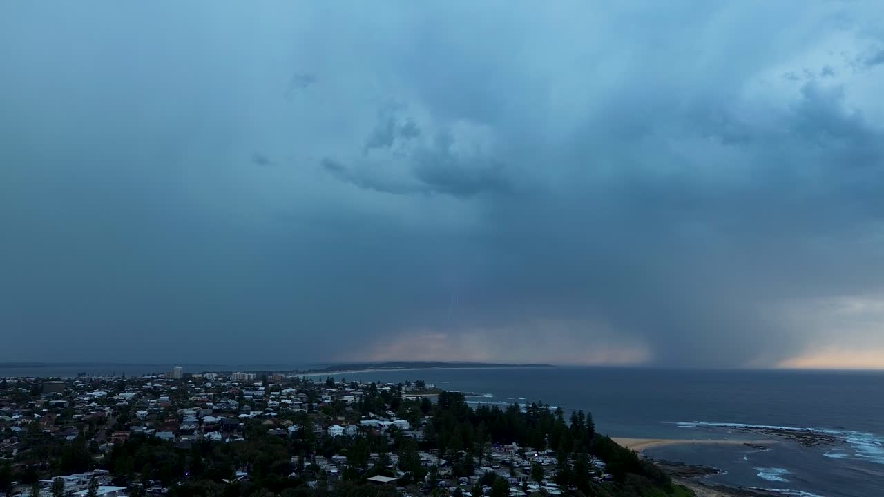 Drone aerial landscape of thunderstorm lightning strikes with dark looming clouds in sky over a suburban rural town on the Central Coast Australia nature environment climate and weather conditions